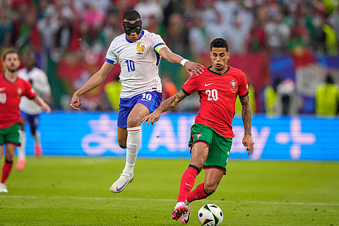 Kylian Mbappe challenges for the ball with Joao Cancelo